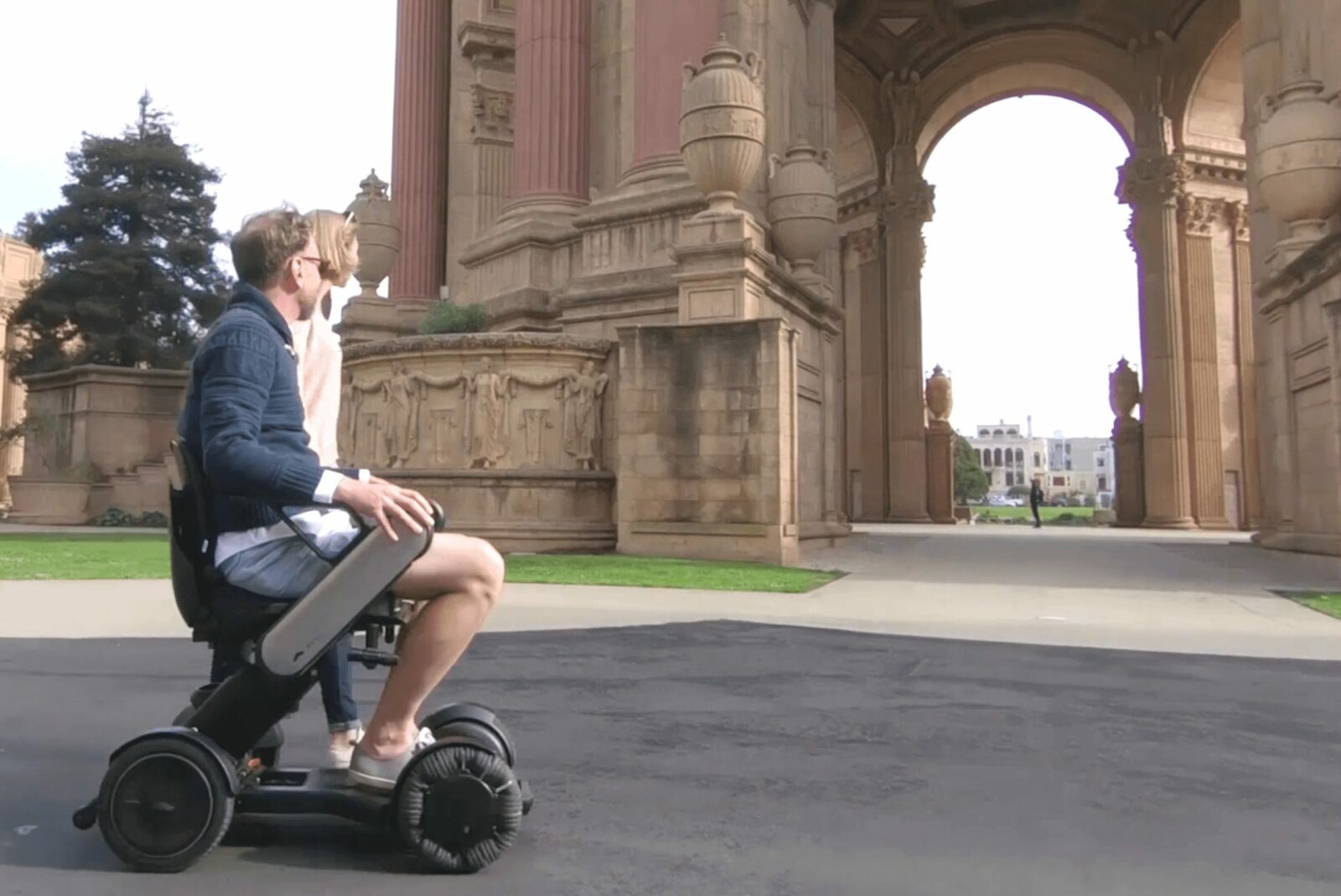 Personne en voyage sur le fauteuil roulant électrique design Whill Model C